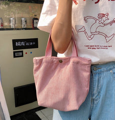 Person holding a pink corduroy bag