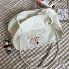 Beige bucket hat with cartoon character patch on a checkered fabric background