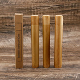 Set of bamboo toothbrushes and packaging on a wooden background