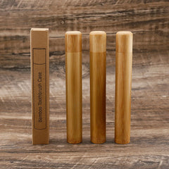 Set of bamboo toothbrushes and packaging on a wooden background