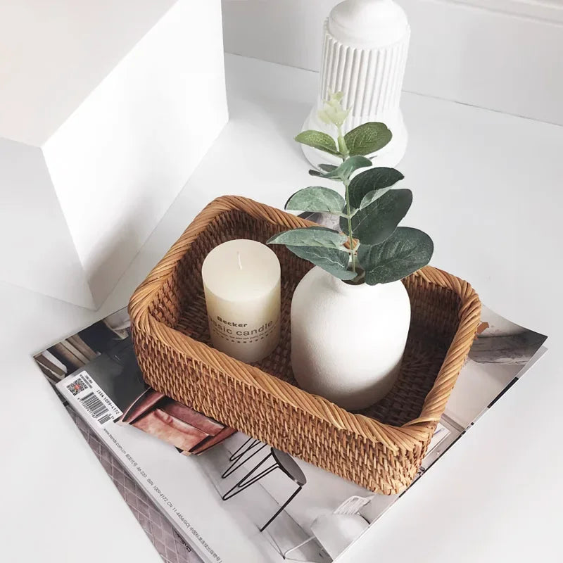 Wicker Handwoven Rattan Storage Basket with a candle and small plant on a magazine