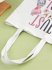 White tote bag with colorful text and design on a green surface