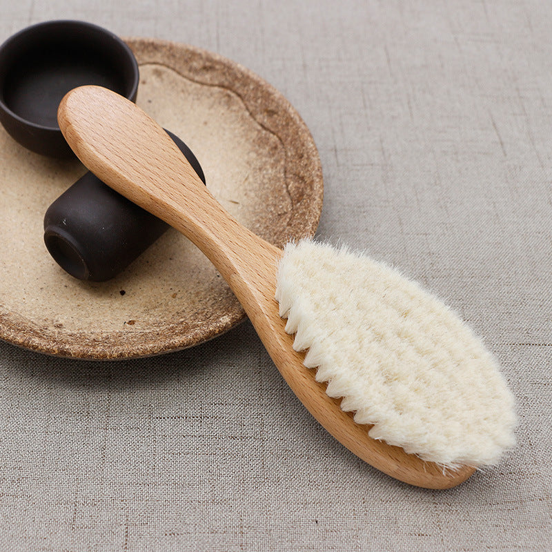 Wooden brush with natural bristles on a textured surface