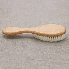Wooden brush with bristles on a textured beige background