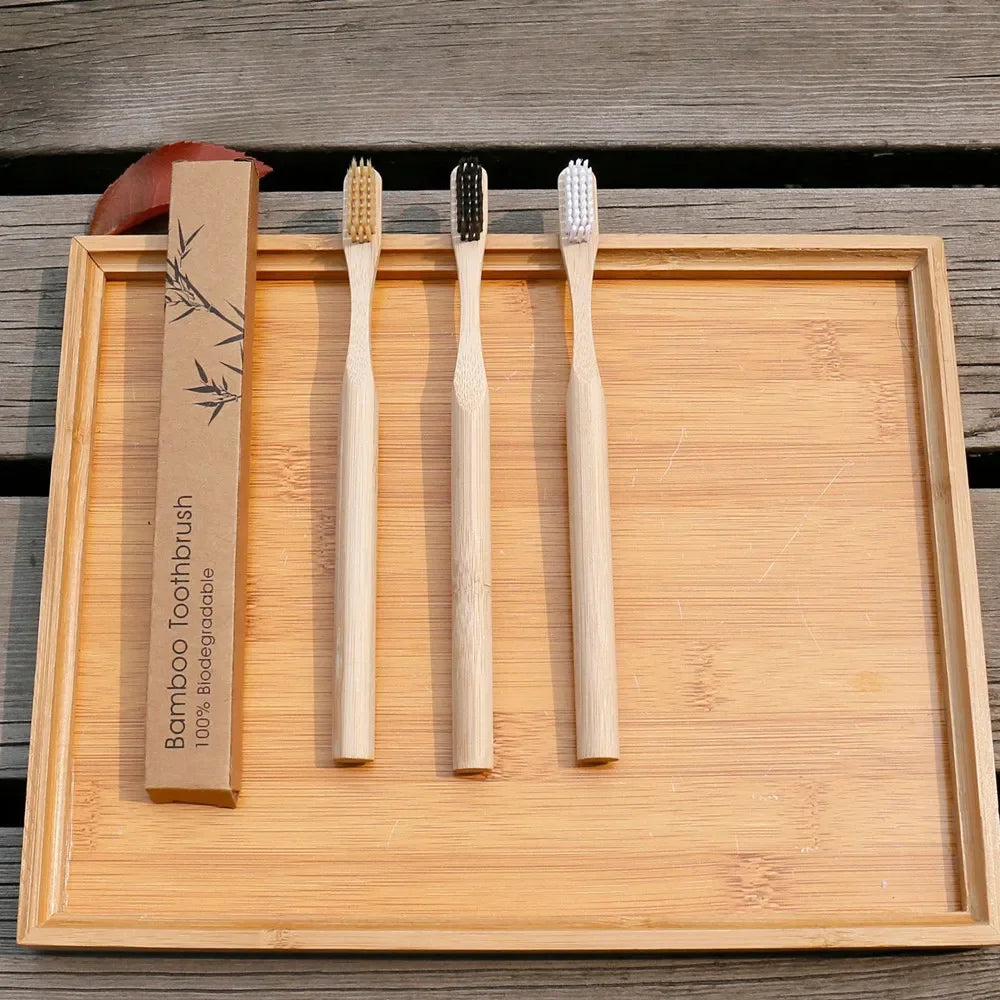 Four bamboo toothbrushes on a wooden tray