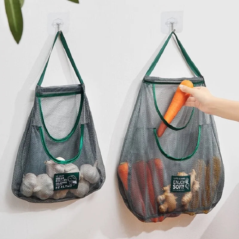 Two mesh grocery bags with vegetables hanging on hooks 