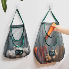 Two mesh grocery bags with vegetables hanging on hooks 